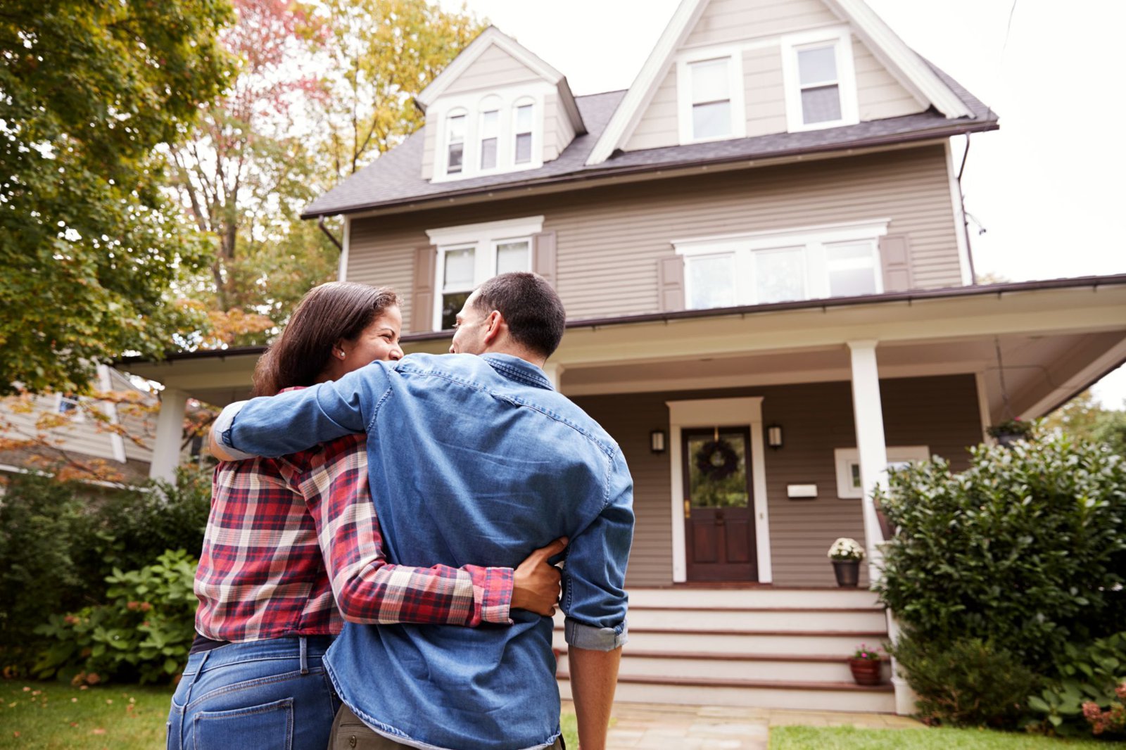 A couple looking at a house from the front yard